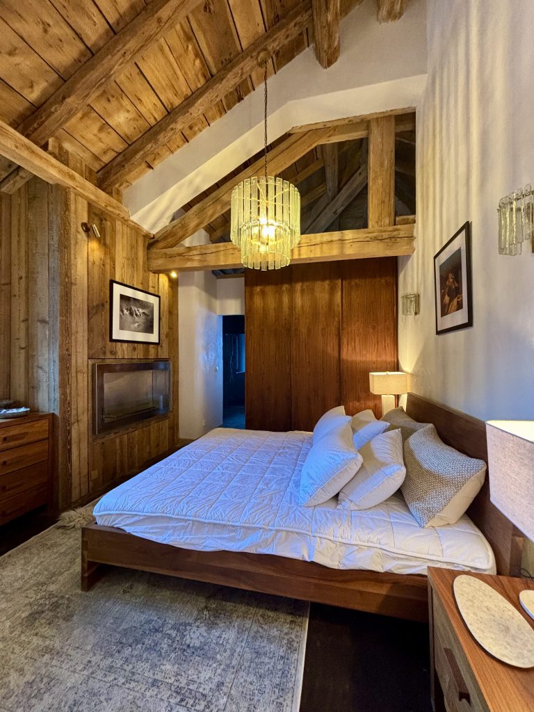 Chambre moderne entièrement rénovée avec des matériaux contemporains, incluant une salle de bain attenante au design épuré et lumineux.